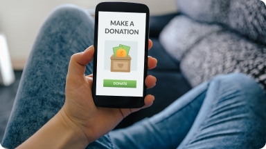 Non-profit eCommerce business website displayed on a mobile phone on their donations page.