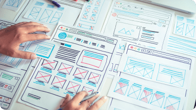 User experience & interface strategy laid out on a desk as a person reviews them.