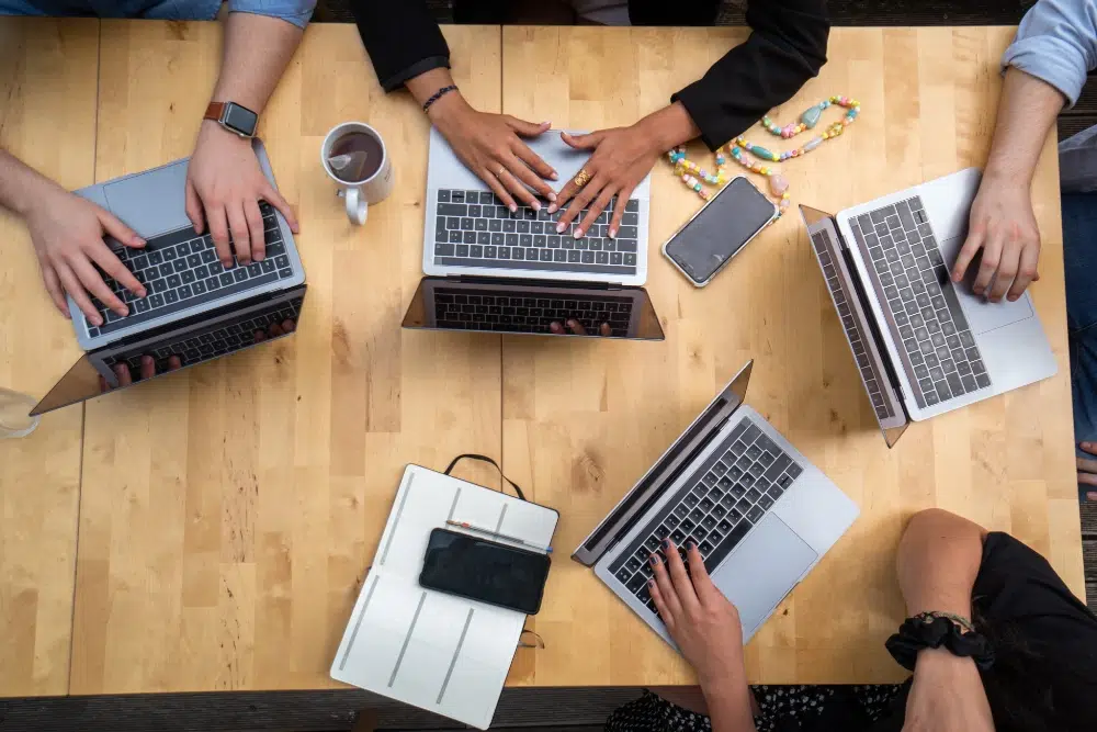 Group of Laptops on a table with their users