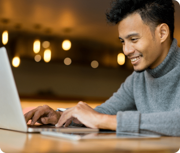 User searching the internet on a laptop in a cafe.