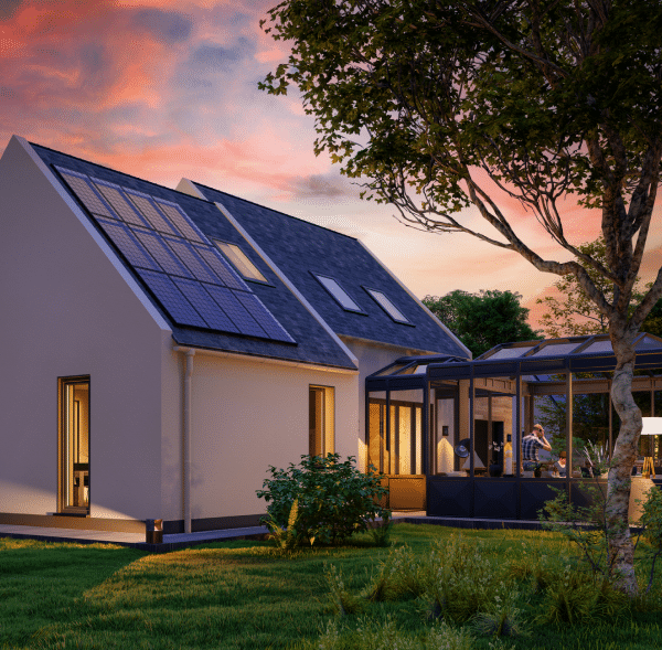 A home with solar panels in the evening with lights on inside the home as people gather outside.