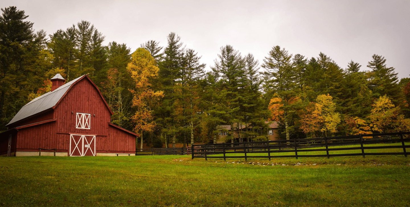 Swaggerty's Sausage farm with red barn and wooden fence, trees with colors of autumn.
