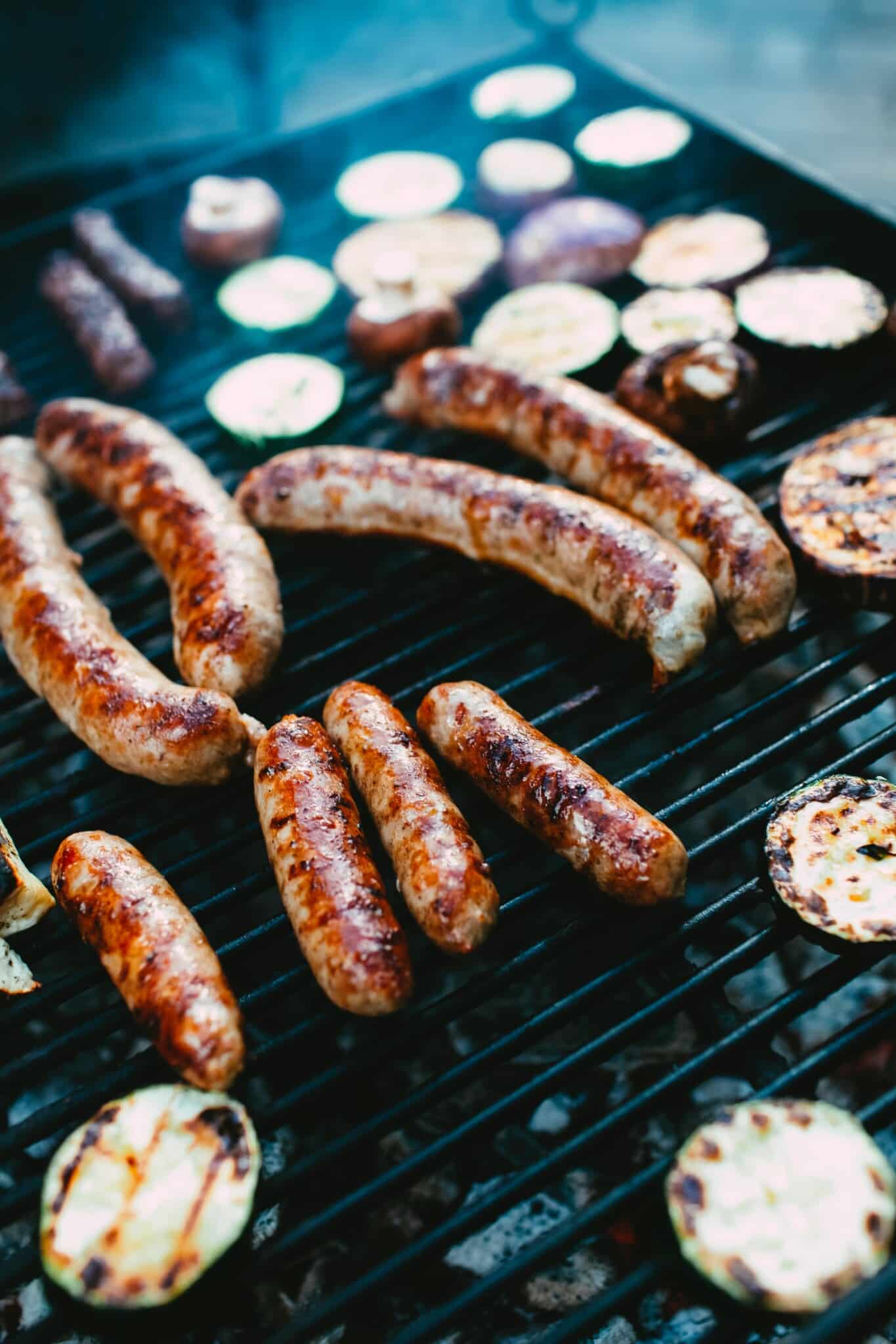 Swaggerty's Sausage links on a grill with grilled vegetables.