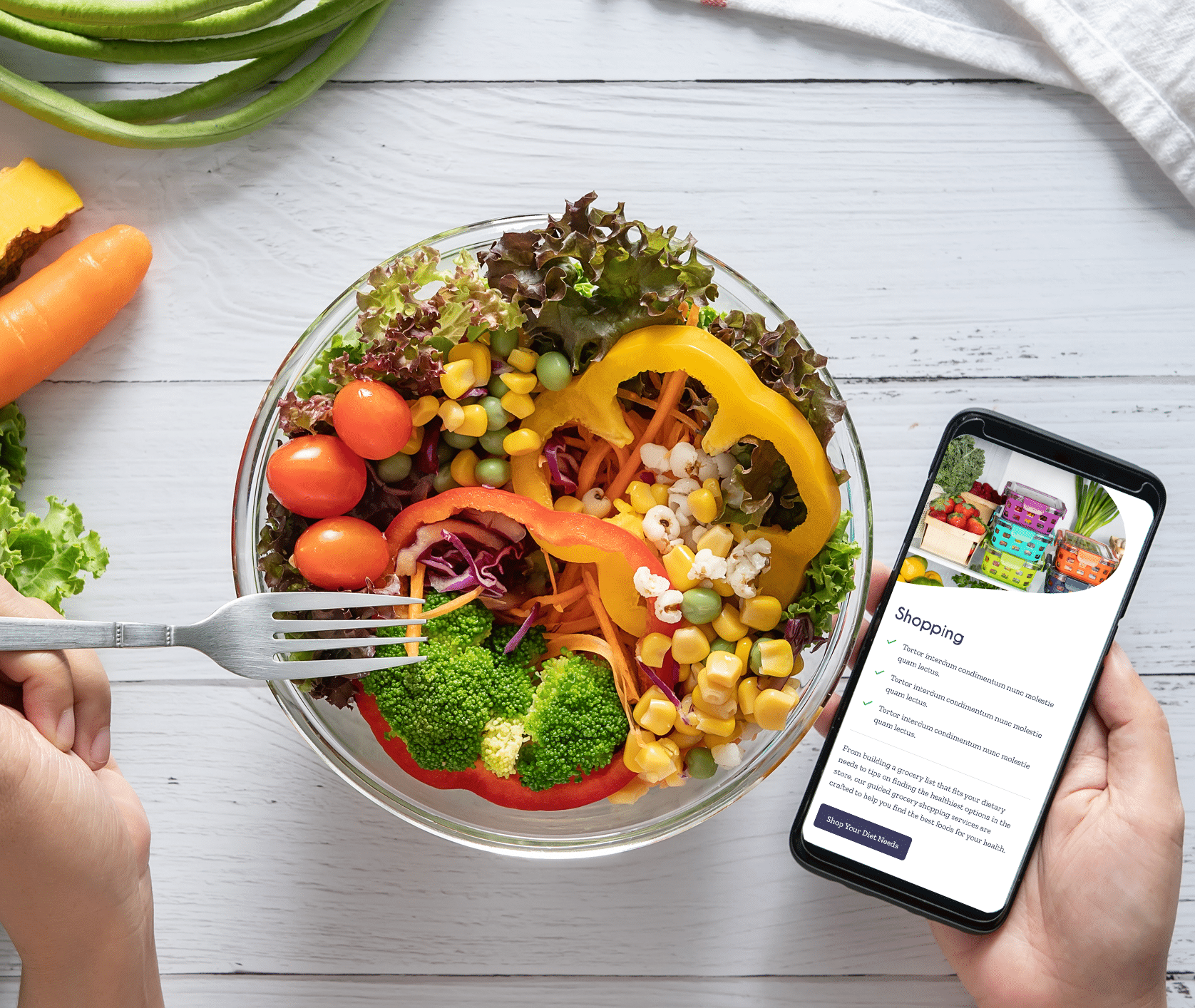 A bowl with ingredients for a salad made with corn and other vegetables with a hand holding a phone with the Dietitian Group shopping page visible.