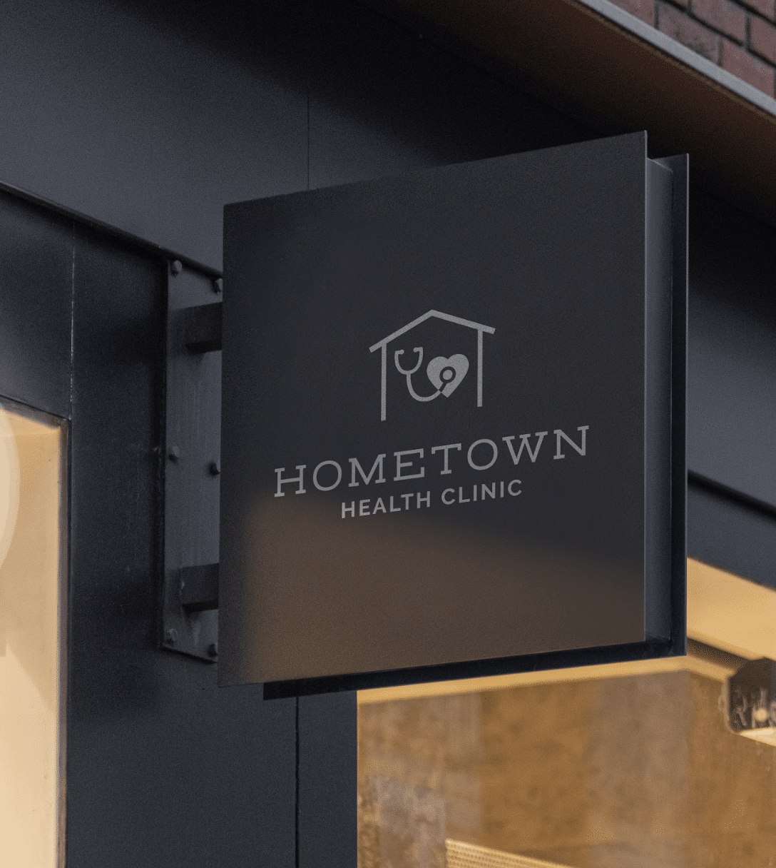 Black square metal sign extends from Hometown Health Clinic building.