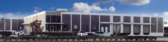 Waldrop building with vehicles parked outside, green bushes and trees landscape the front.