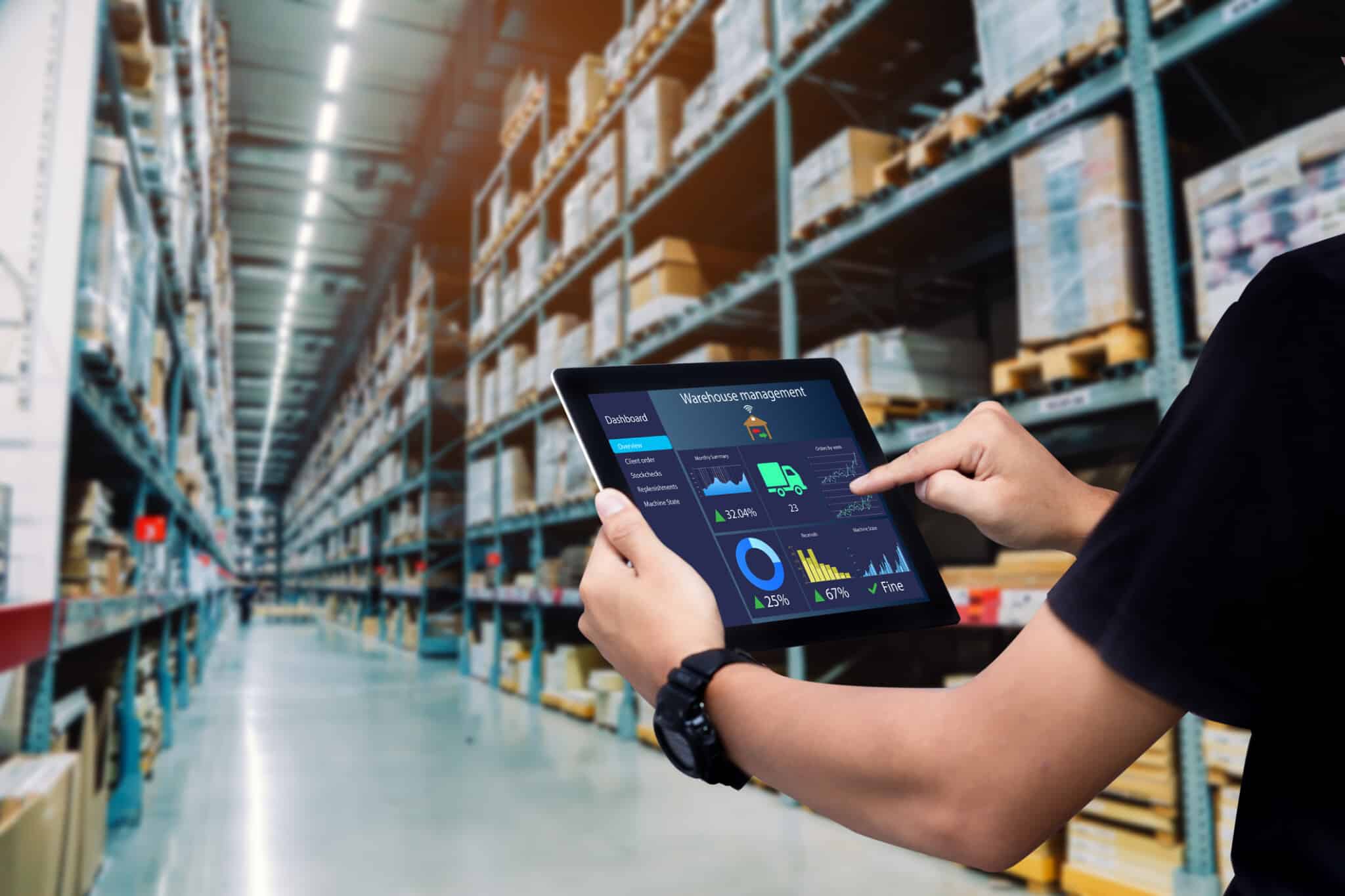 Arm holds out a tablet with a persons hand moving across the warehouse management program.