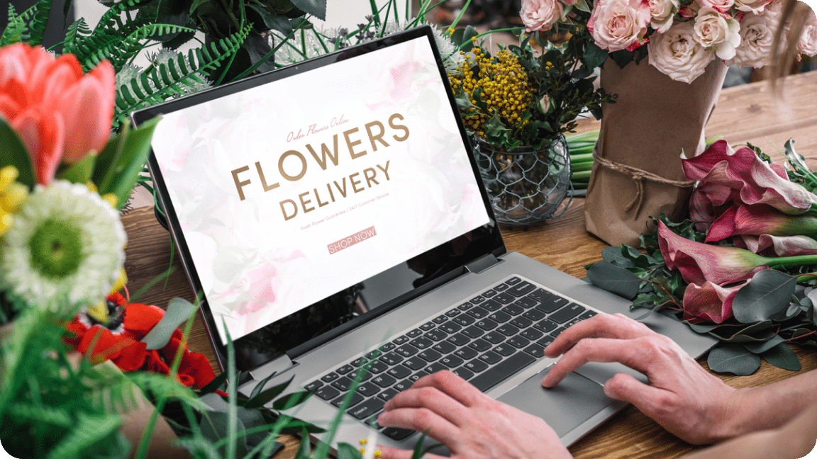 Flower shop website homepage displayed on a laptop as the owner looks at it.
