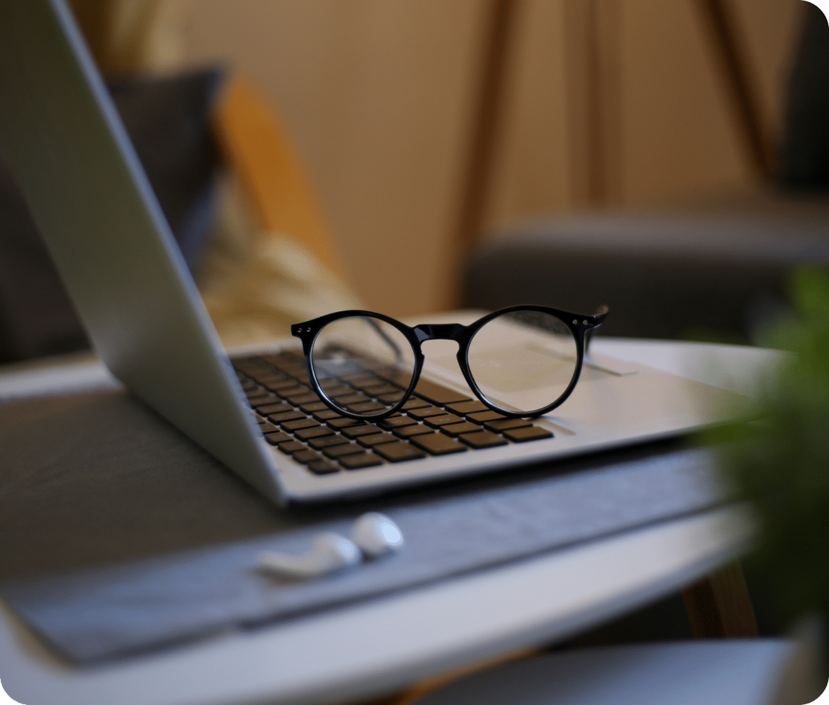 Open laptop with black rimmed glasses laying on the keyboard.
